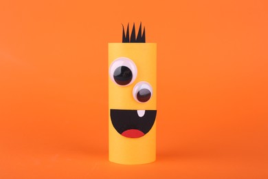 Spooky paper monster on orange background. Handmade Halloween decoration