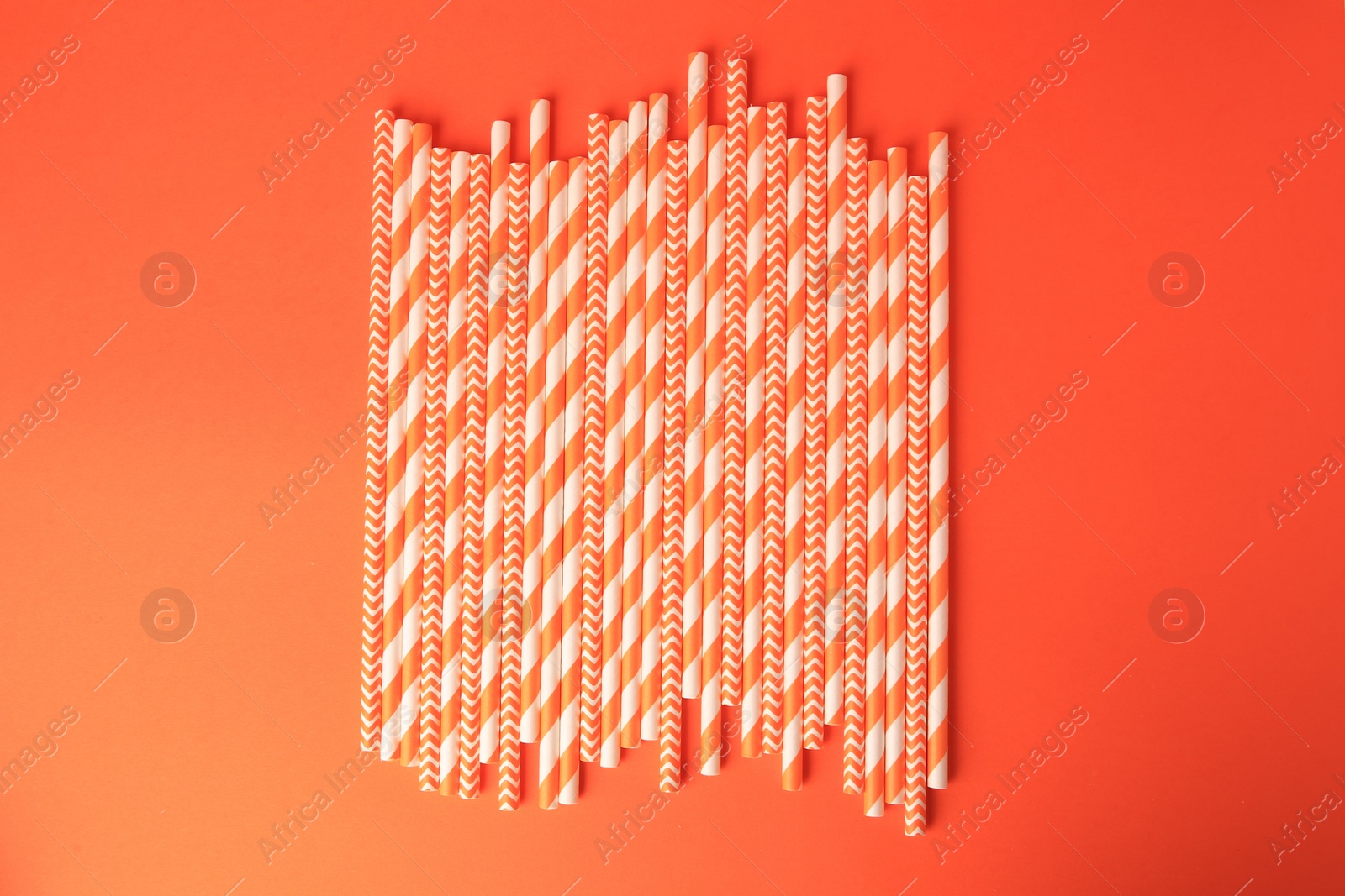 Photo of Many paper drinking straws on orange background, flat lay