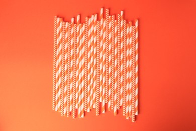 Many paper drinking straws on orange background, flat lay
