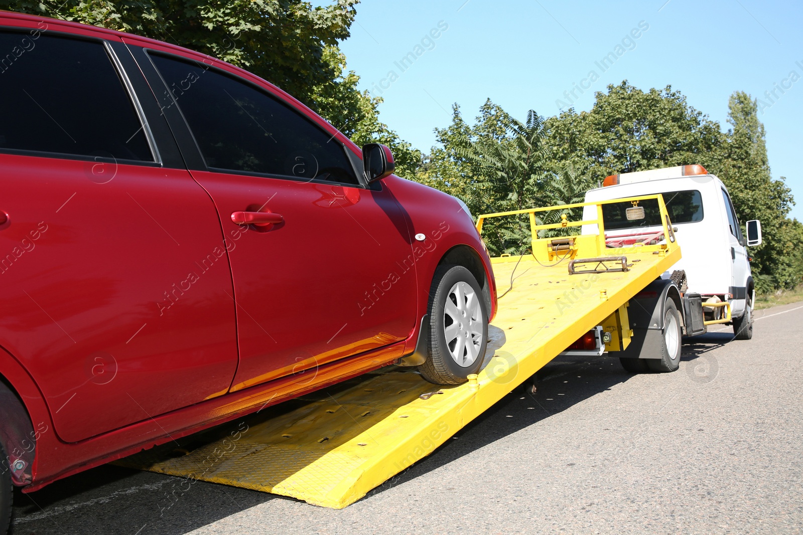 Photo of Broken car and tow truck on country road