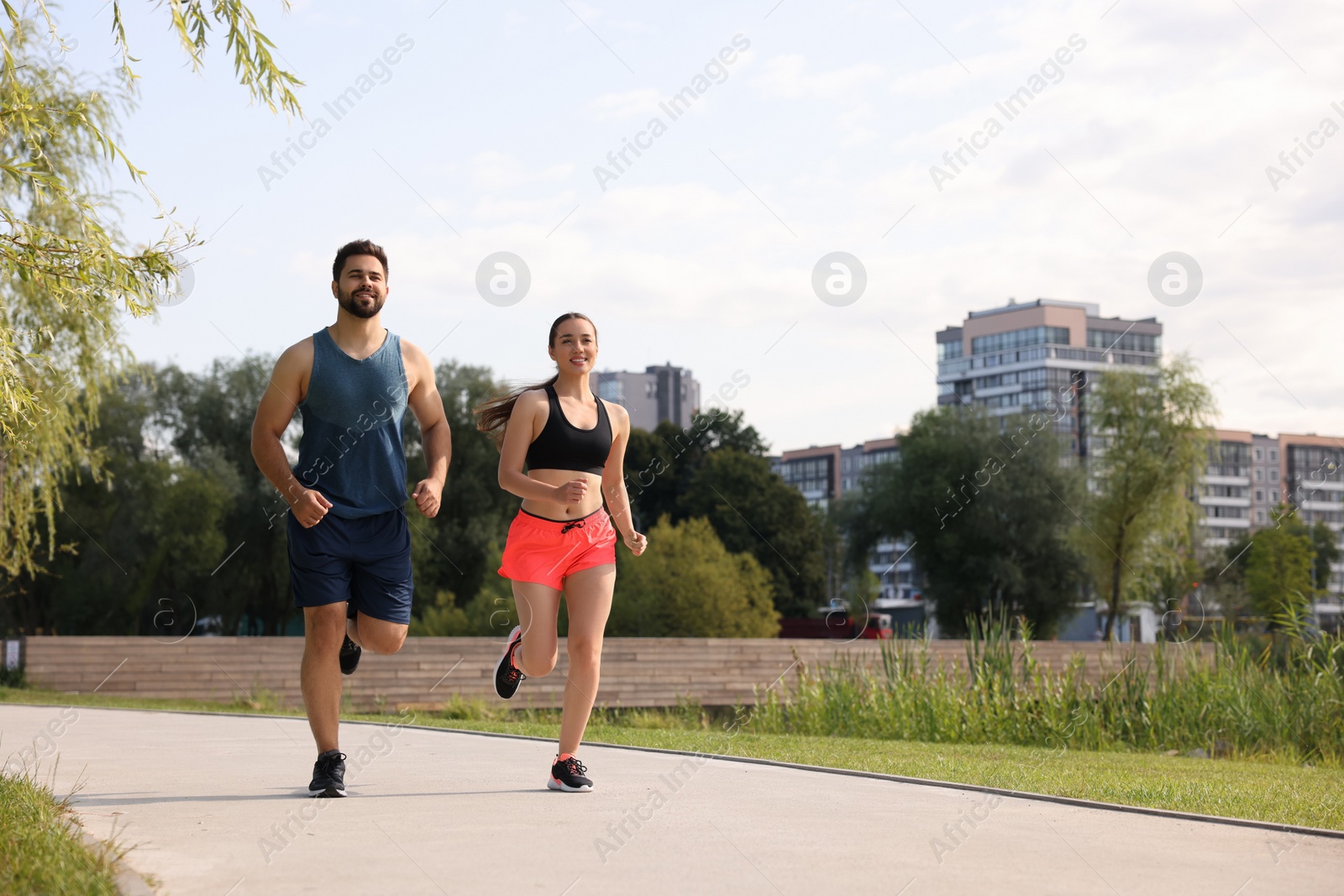 Photo of Healthy lifestyle. Happy couple running outdoors, space for text