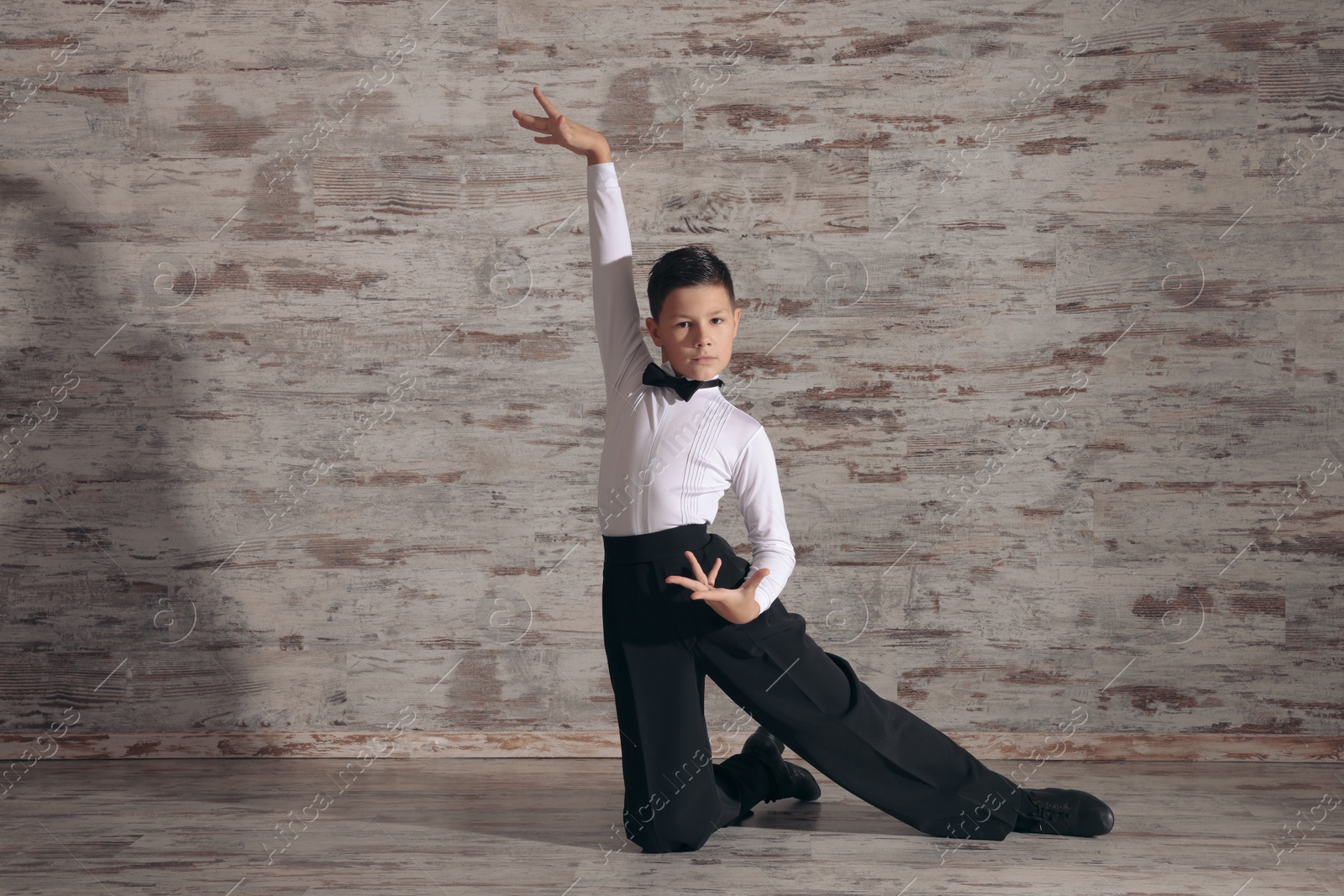 Photo of Beautifully dressed little boy dancing in studio