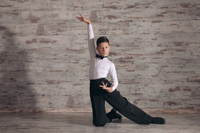 Beautifully dressed little boy dancing in studio