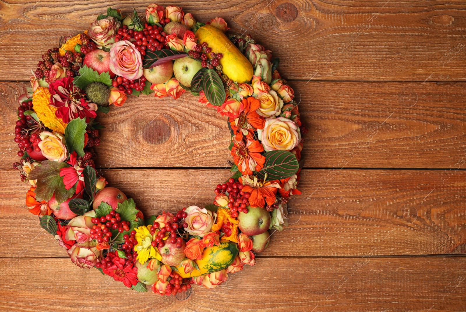 Photo of Beautiful autumnal wreath with flowers, berries and fruits on wooden background, top view. Space for text