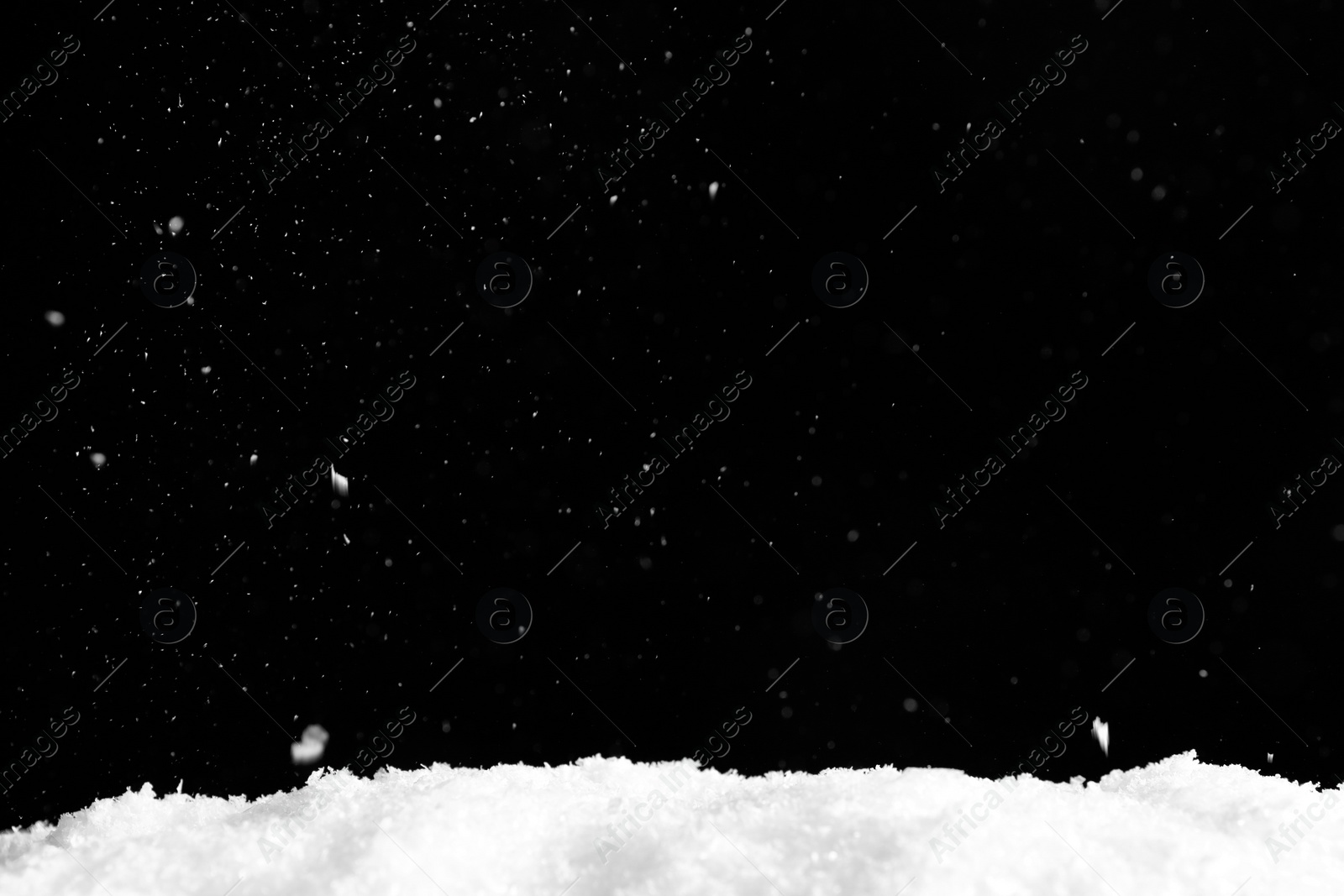 Photo of Snow flakes falling on black background. Winter weather