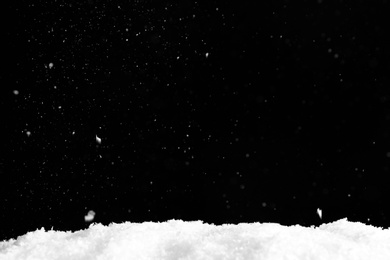 Photo of Snow flakes falling on black background. Winter weather