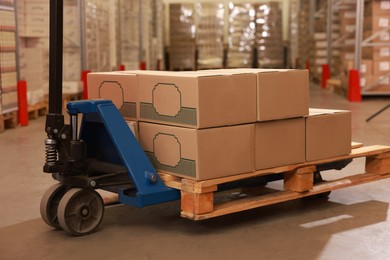 Image of Manual forklift with cardboard boxes in warehouse. Logistics concept