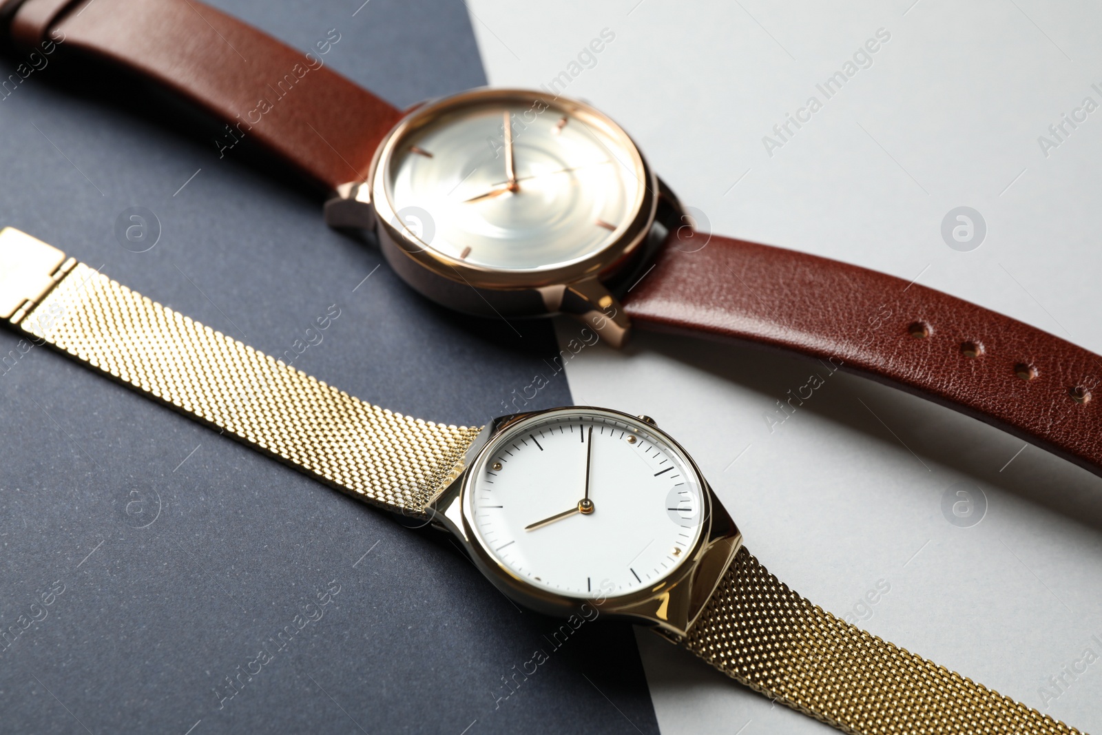 Photo of Luxury wrist watches on color background, closeup