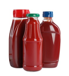 Different bottles of ketchup on white background