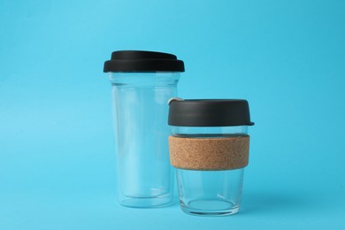 Photo of Glass cups on light blue background. Conscious consumption