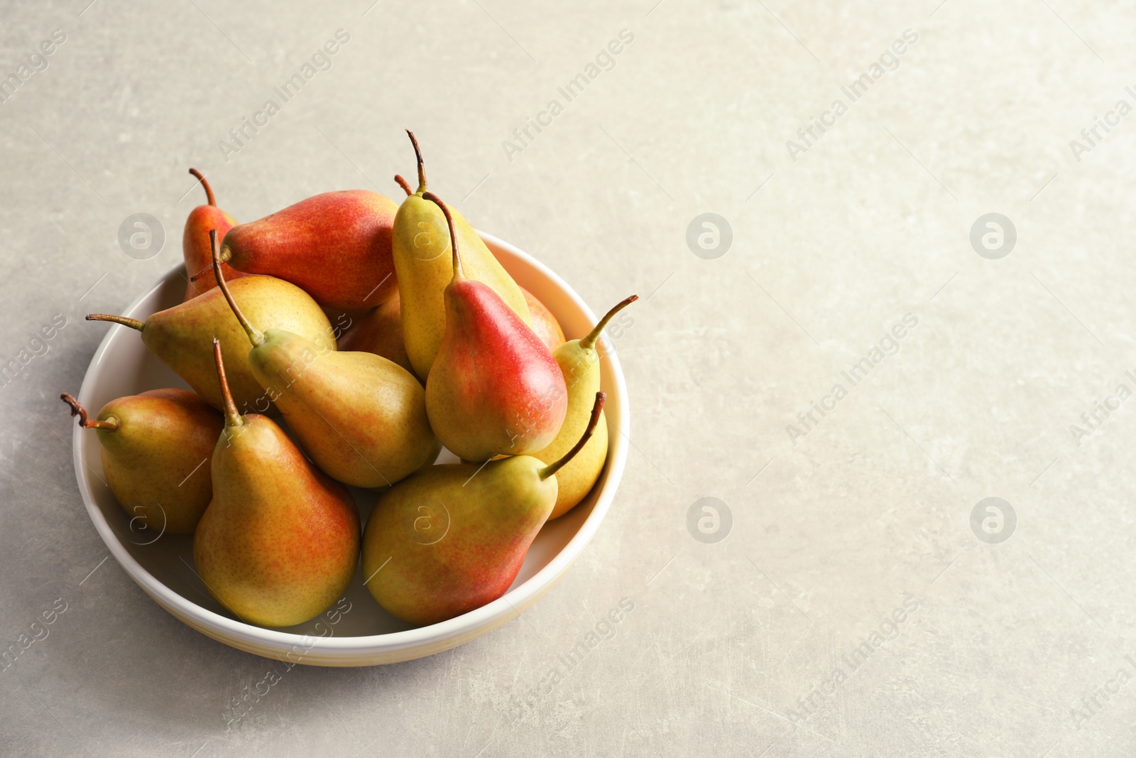 Photo of Plate with ripe pears on grey background. Space for text