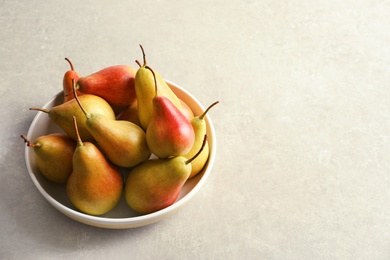 Photo of Plate with ripe pears on grey background. Space for text