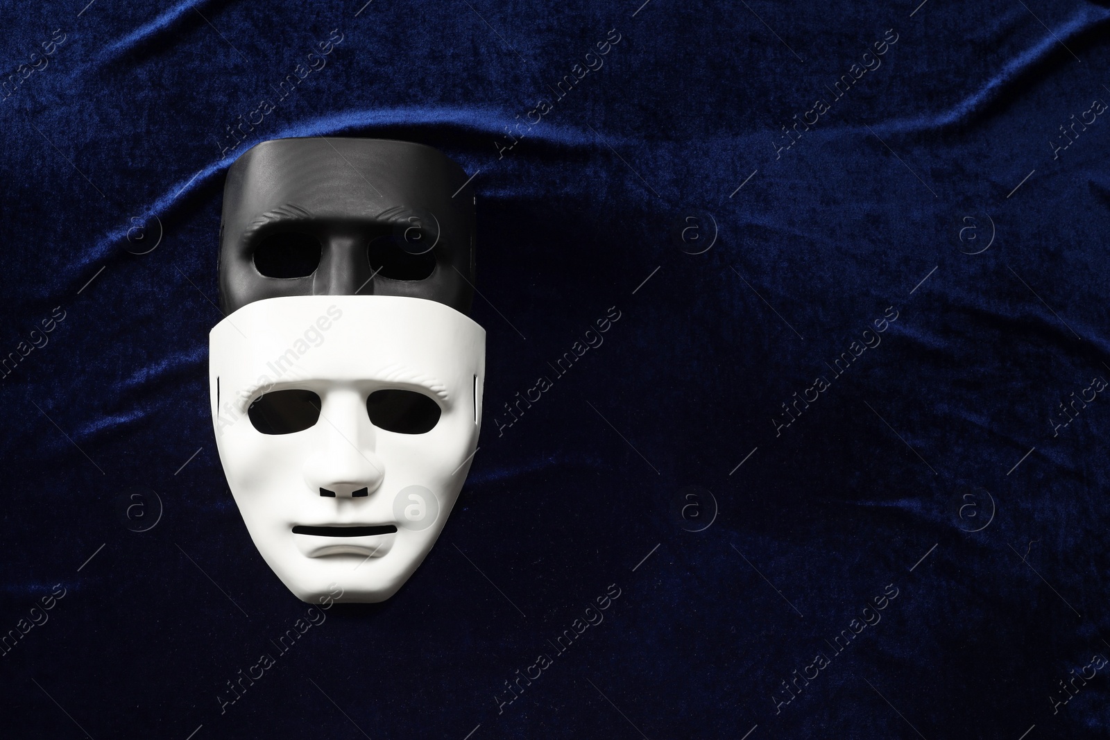 Photo of Theater arts. Two masks on blue fabric, top view. Space for text