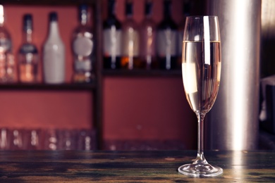 Photo of Glass of champagne on wooden counter in bar