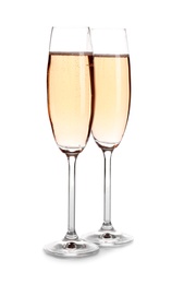 Photo of Glasses of rose champagne on white background. Festive drink