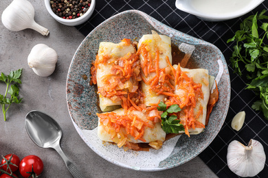 Photo of Delicious cabbage rolls served on grey table, flat lay