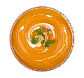 Photo of Delicious pumpkin soup with seeds and parsley in bowl isolated on white, top view