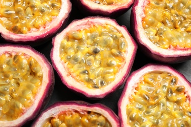 Halves of passion fruits (maracuyas) on table, flat lay