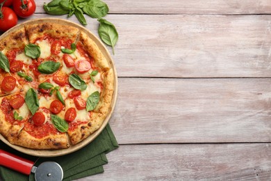 Photo of Delicious Margherita pizza and cutter on wooden table, flat lay. Space for text