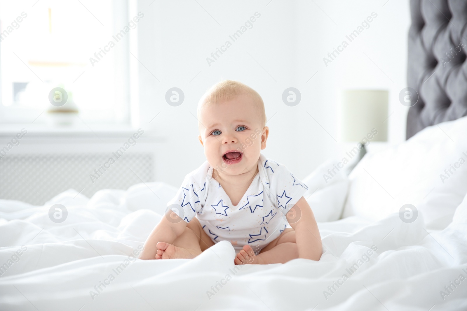 Photo of Cute little baby crawling on bed at home