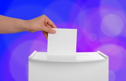 Woman putting her vote into ballot box on color background, closeup