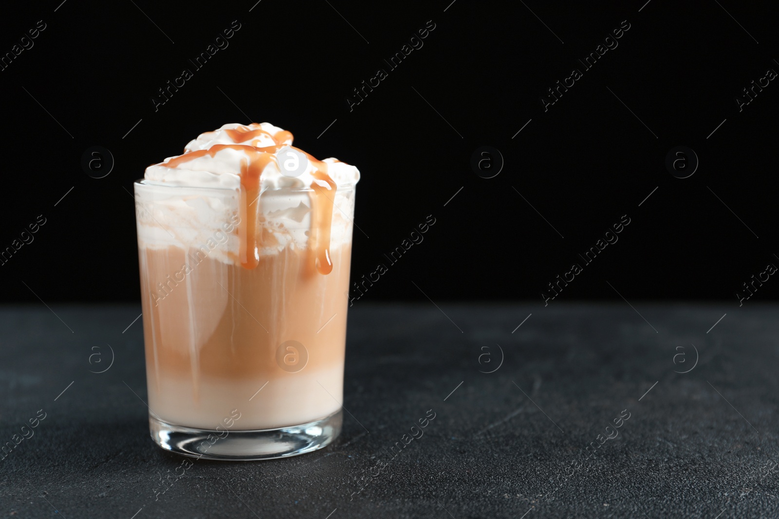 Photo of Glass with delicious caramel frappe on table