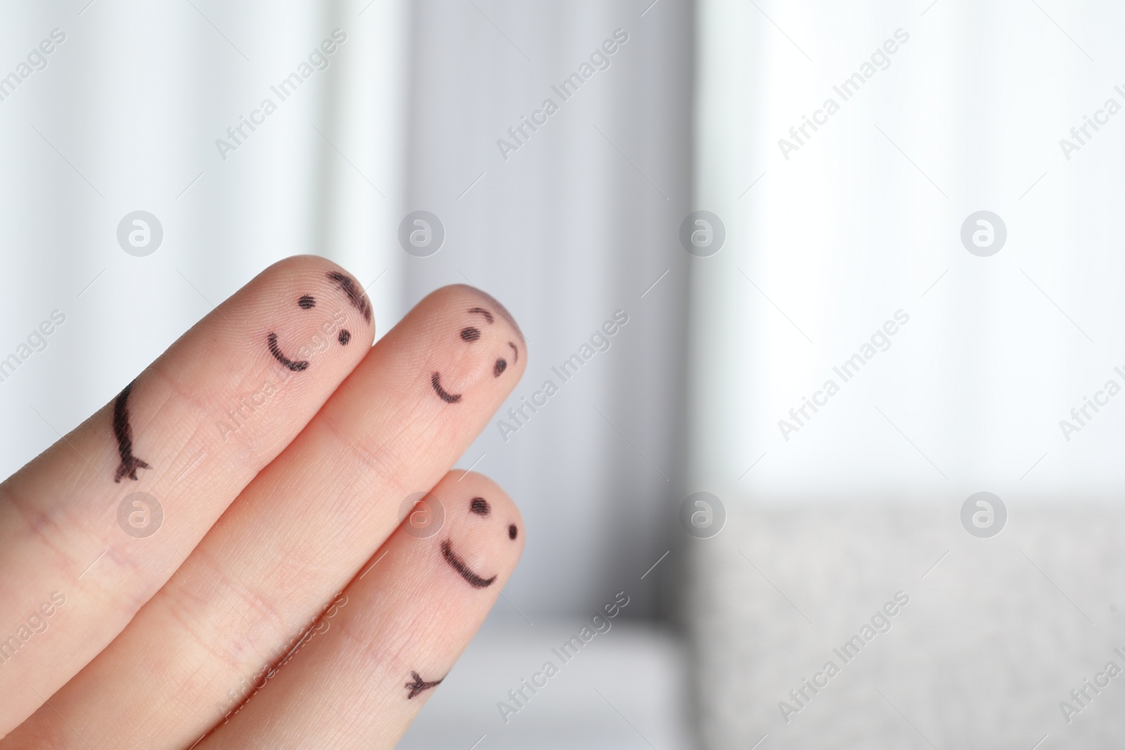 Photo of Three fingers with drawings of happy faces on blurred background, space for text