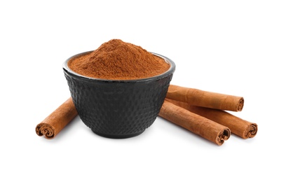 Photo of Aromatic cinnamon sticks and bowl with powder on white background