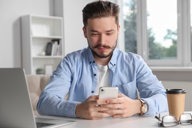 Photo of Man using smartphone while working in office