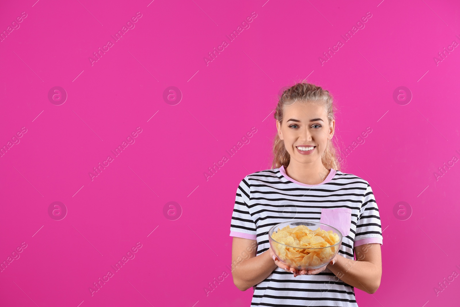 Photo of Woman with bowl of potato chips on color background. Space for text