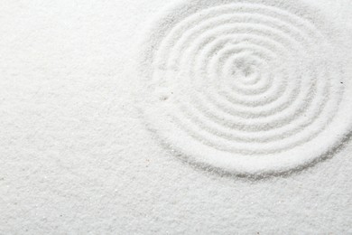 Zen rock garden. Circle pattern on white sand