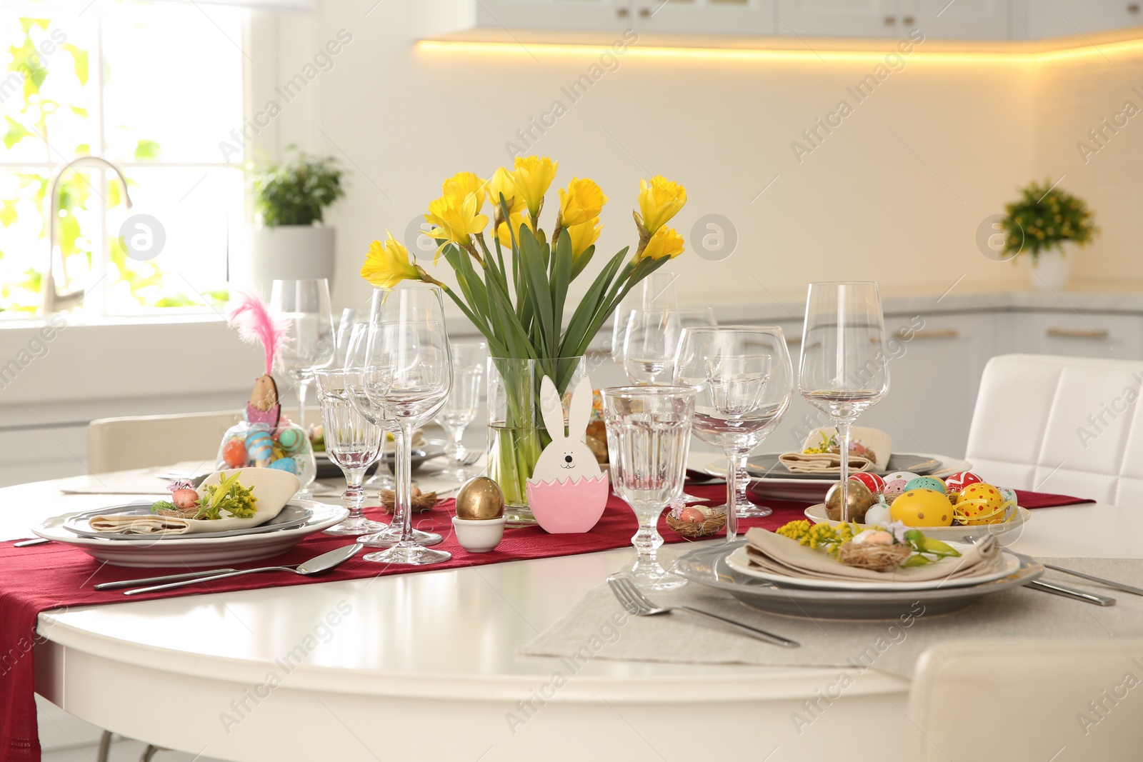 Photo of Festive Easter table setting with floral decor in kitchen