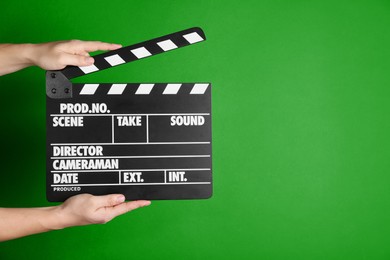 Second assistant camera holding clapper board against chroma key background, closeup. Space for text