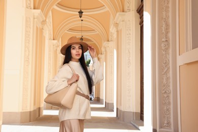 Photo of Young woman with stylish bag outside beautiful building