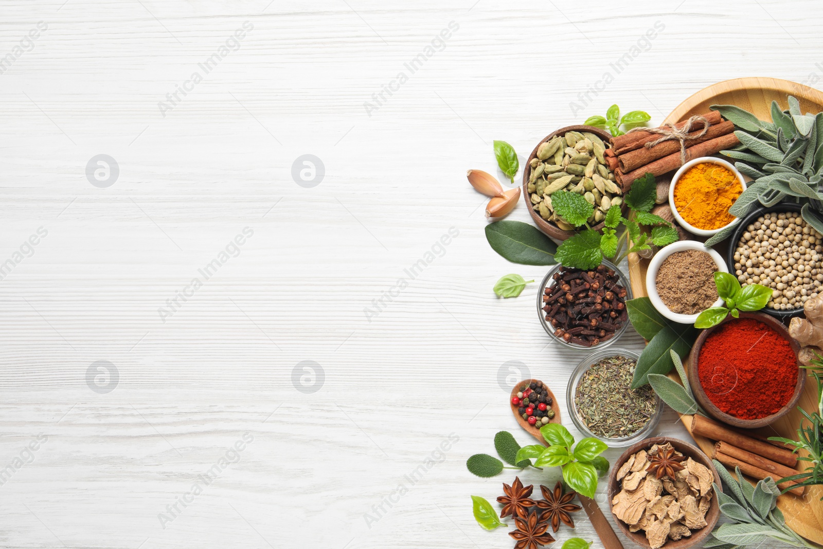 Photo of Different fresh herbs and spices on white wooden table, flat lay. Space for text