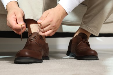 Groom putting on his shoes indoors, closeup. Wedding day