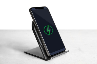 Mobile phone charging with wireless pad on light stone table