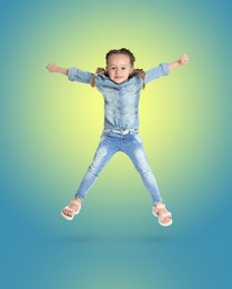 Happy cute girl jumping on color gradient background