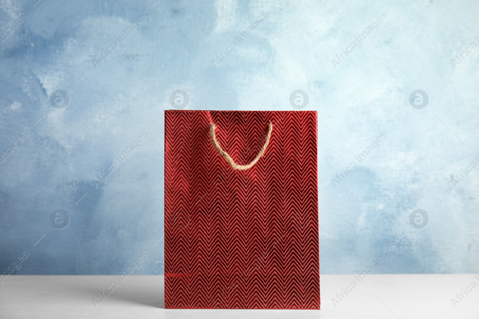 Photo of Red shopping paper bag on white table