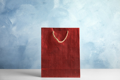 Photo of Red shopping paper bag on white table