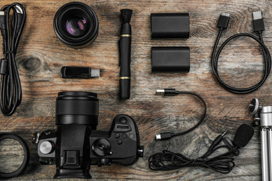 Photo of Flat lay composition with camera and video production equipment on wooden table