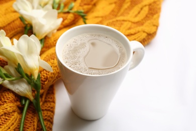 Photo of Composition with coffee and warm plaid on white background, closeup