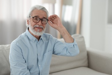 Photo of Portrait of grandpa with stylish glasses on sofa indoors