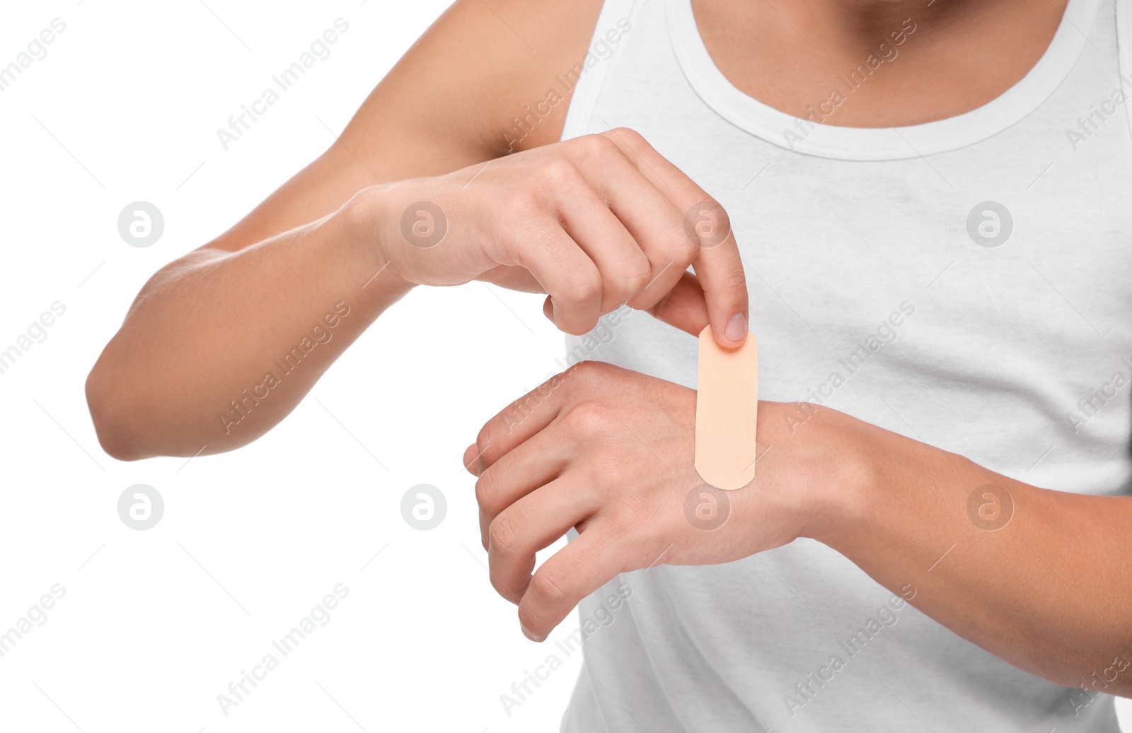 Photo of Man putting sticking plaster onto hand on white background, closeup