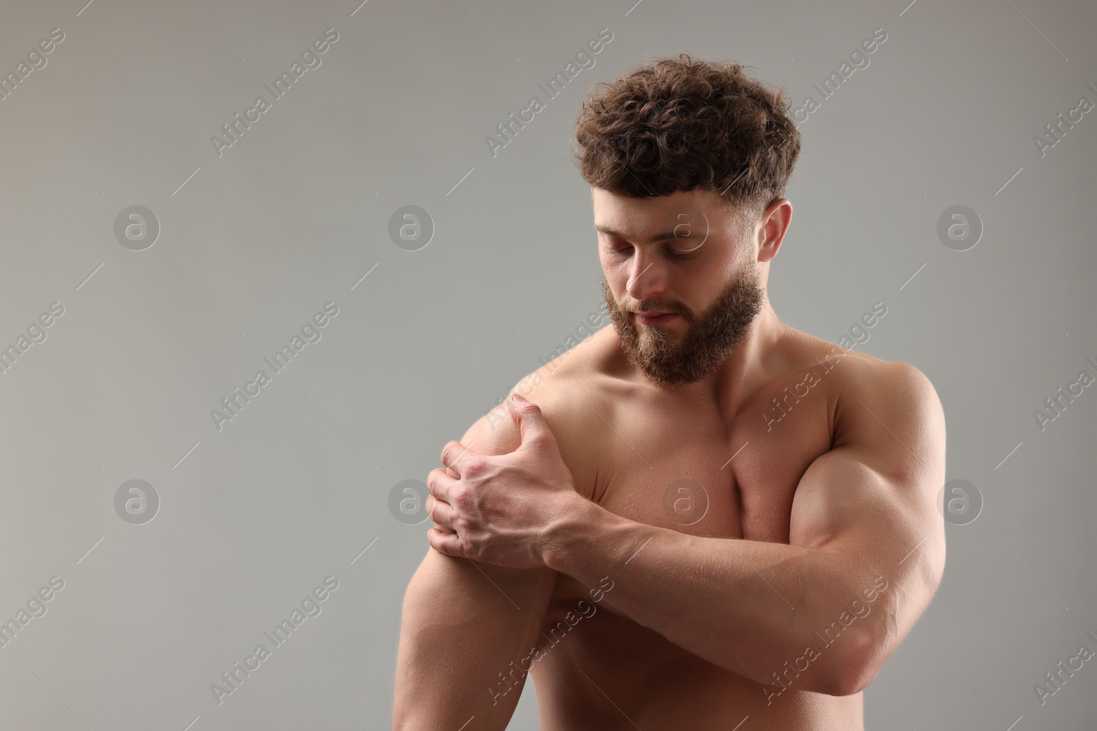 Photo of Handsome man with muscular body on light grey background. Space for text