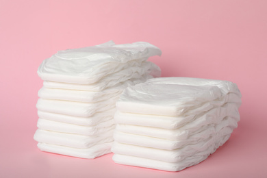 Photo of Stacks of baby diapers on pink background