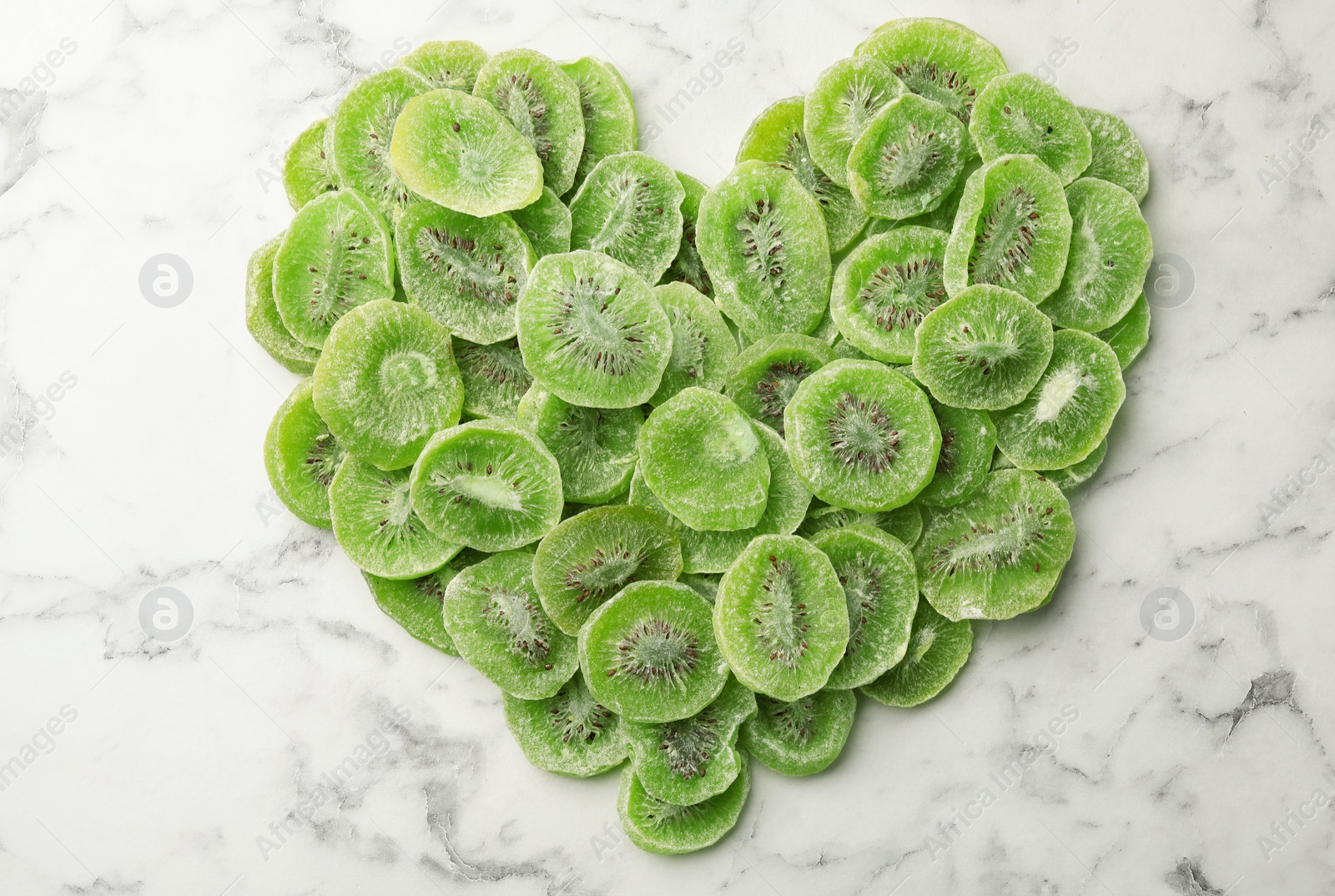 Photo of Slices of kiwi on marble background, top view. Dried fruit as healthy food
