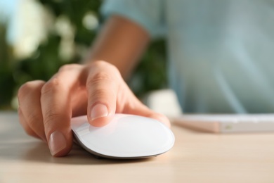 Photo of Woman using computer mouse at table, closeup