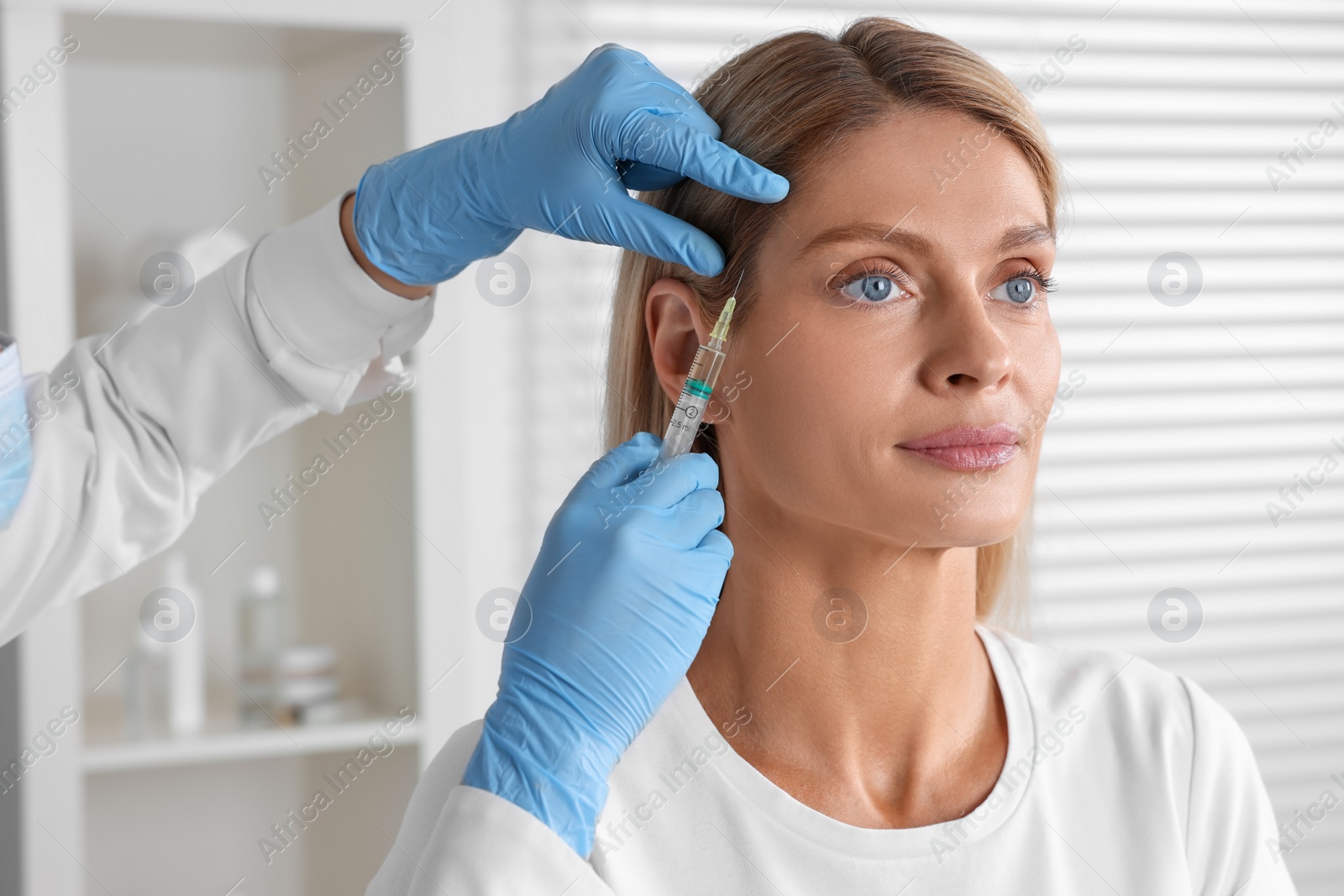 Photo of Trichologist giving injection to patient in clinic, closeup