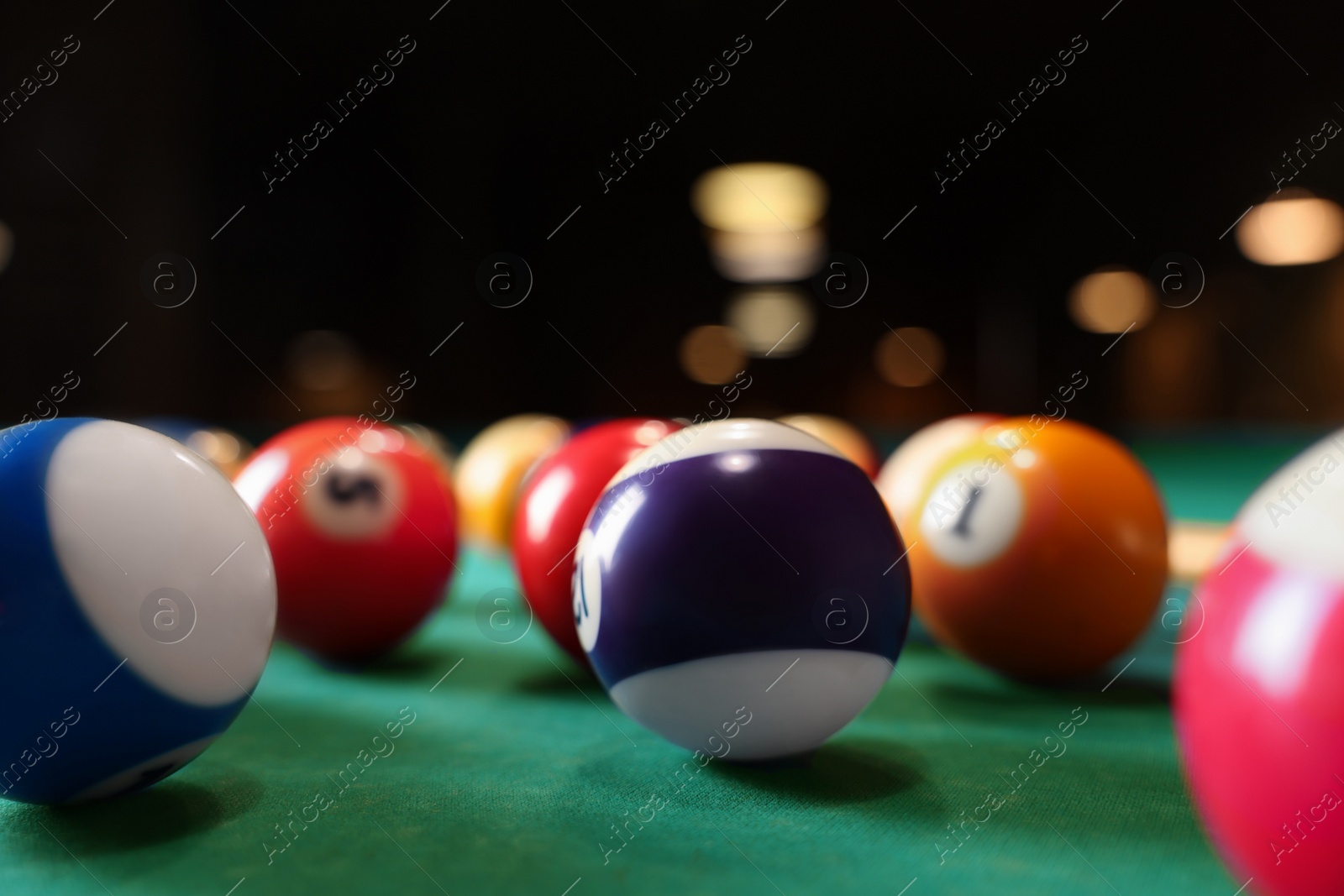 Photo of Many colorful billiard balls on green table, closeup